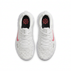 Top view of white Nike sneakers with pink Swooshes and black insoles on white background