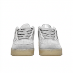 Front view of light grey Nike sneakers with grey laces and perforated toes on white.