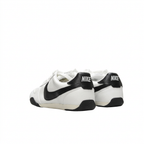 Rear view of white Nike sneakers with black Swoosh details and black heel tabs on white.