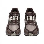 Front view of dark brown and taupe striped mesh Nike sneakers with brown laces and cream details on white.