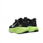 Black Nike sneakers with neon-lime soles and heel loops, rear angled view on white background