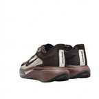 Rear view of dark brown Nike sneakers with cream heel strips and sculpted brown soles on white.