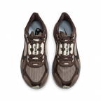 Top view of dark brown and taupe Nike sneakers with brown laces and cream tongue details on white.