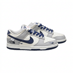 Grey white and navy Nike low-top sneaker pair with printed side lettering, angled view
