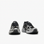 Black and silver Nike sneakers with cage-like overlays, front view on white
