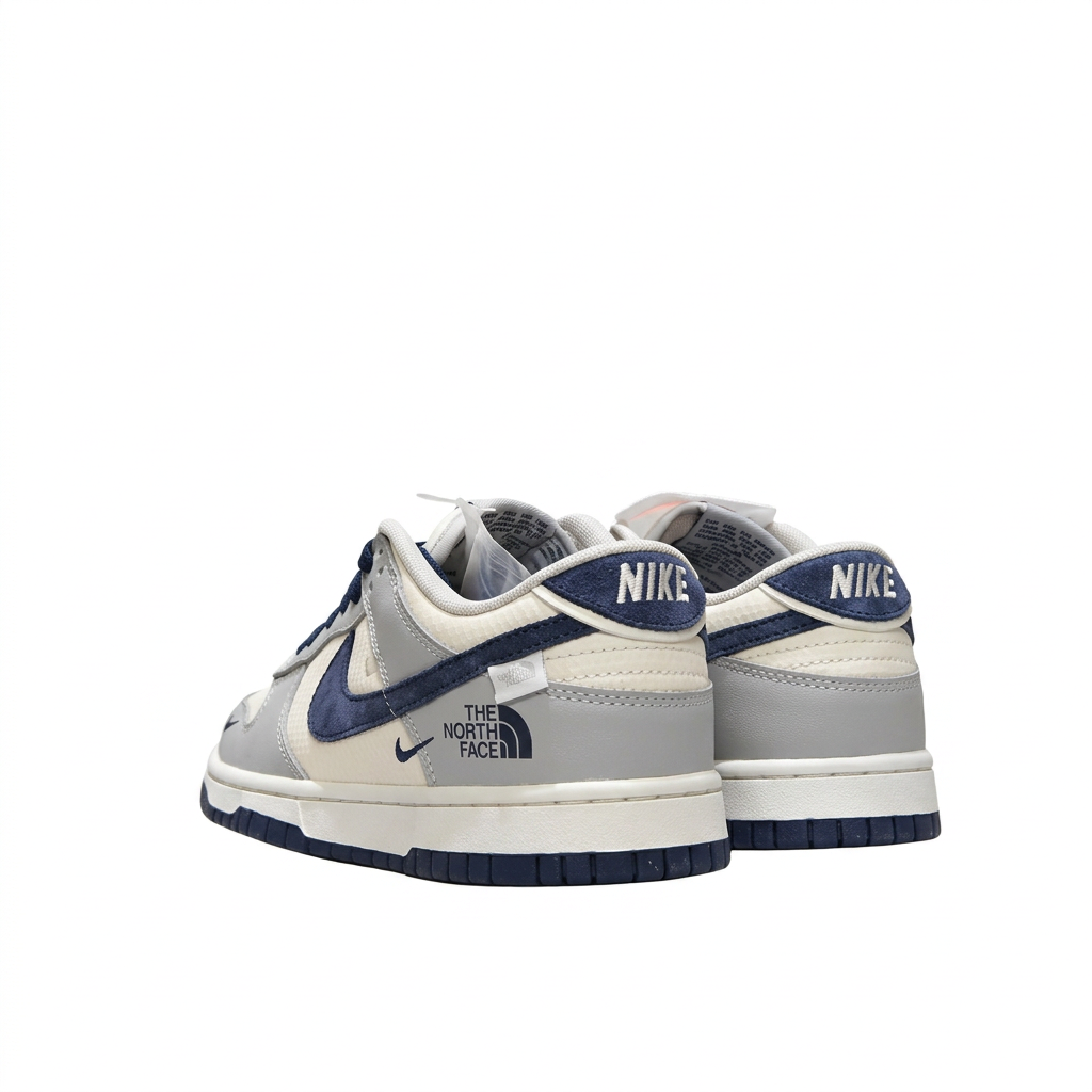 Grey white and navy Nike sneakers with NIKE heel tabs, rear angled view on white background