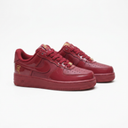 Burgundy Nike sneakers with tonal Swooshes, angled view on white