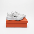 White Nike ZoomX low-top sneakers on an orange shoe box