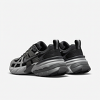 Black Nike sneakers with grey chunky soles and heel tabs, rear view on white