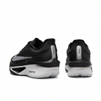 Black Nike sneakers with white soles, rear view on white background