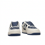 Front view of cream and navy patterned sneakers with navy speckled laces on white.