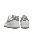 White Nike Air Force 1 sneakers with grey Nike Air heel tabs, rear view on white background