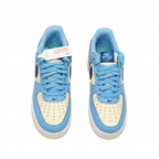 Light blue and cream Nike Air Force 1 sneakers with blue laces, overhead view on white background