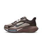 Left-facing dark brown and taupe Nike sneaker with charcoal Swoosh and blue forefoot window on white.