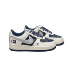 Pair of cream and navy patterned Nike sneakers with grey Swoosh details on white.