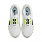 Top view of white Nike sneakers with neon lime lace accents and black Swoosh details on white.