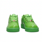 Glossy green Nike Air Force 1 sneakers with metallic lace tags, front view on white background
