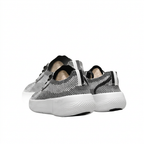 Rear view of black and white textured Nike sneakers with heel strip details and thick white soles.