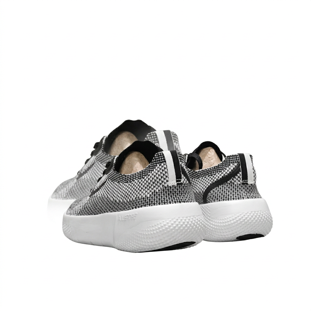 Rear view of black and white textured Nike sneakers with heel strip details and thick white soles.