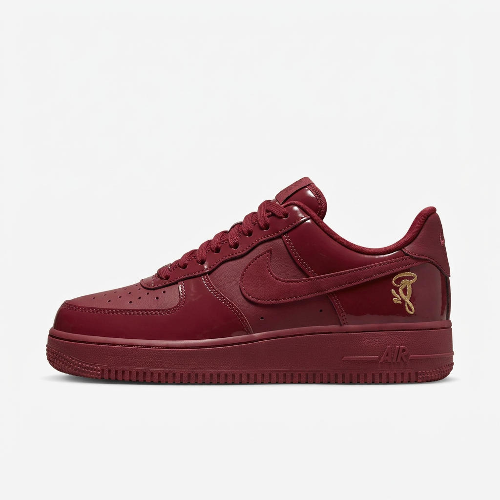 Burgundy Nike low-top sneaker with gold details, side view on white