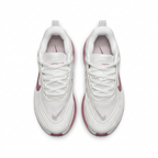 White Nike sneakers with pink accents and white laces, overhead view on white background