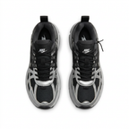 Black and silver Nike sneakers with black laces, top view on white