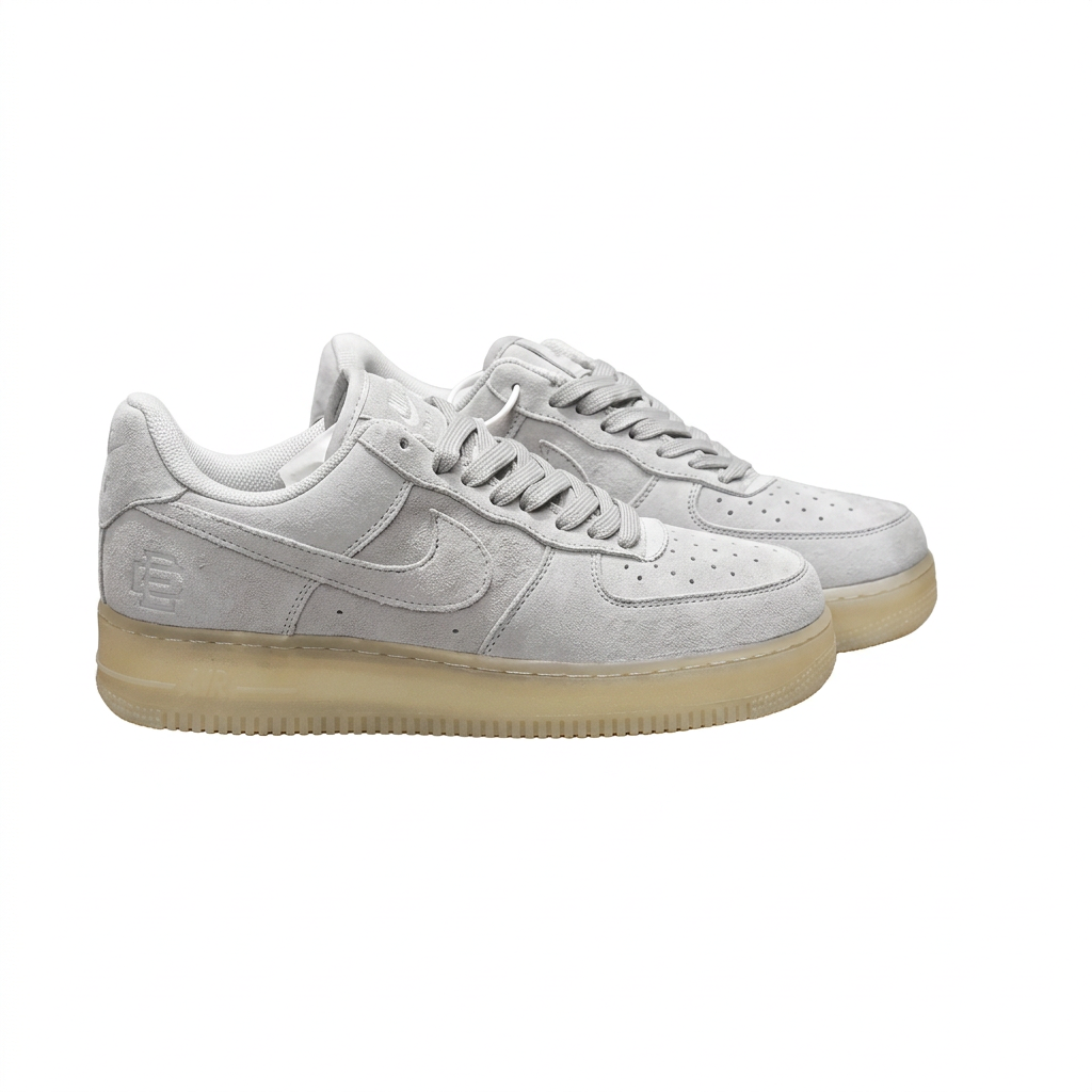 Pair of light grey Nike sneakers with tonal Swoosh and translucent pale yellow soles on white.