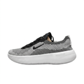 Left-facing black and white textured Nike sneaker with black Swoosh and thick white sole on white.