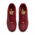 Burgundy Nike sneakers with gold-colored lace hardware, top view on white