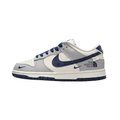 Grey and white Nike low-top sneaker with navy Swoosh and printed side lettering, side view