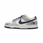 Grey and white Nike low-top sneaker with navy Swoosh and printed side lettering, side view