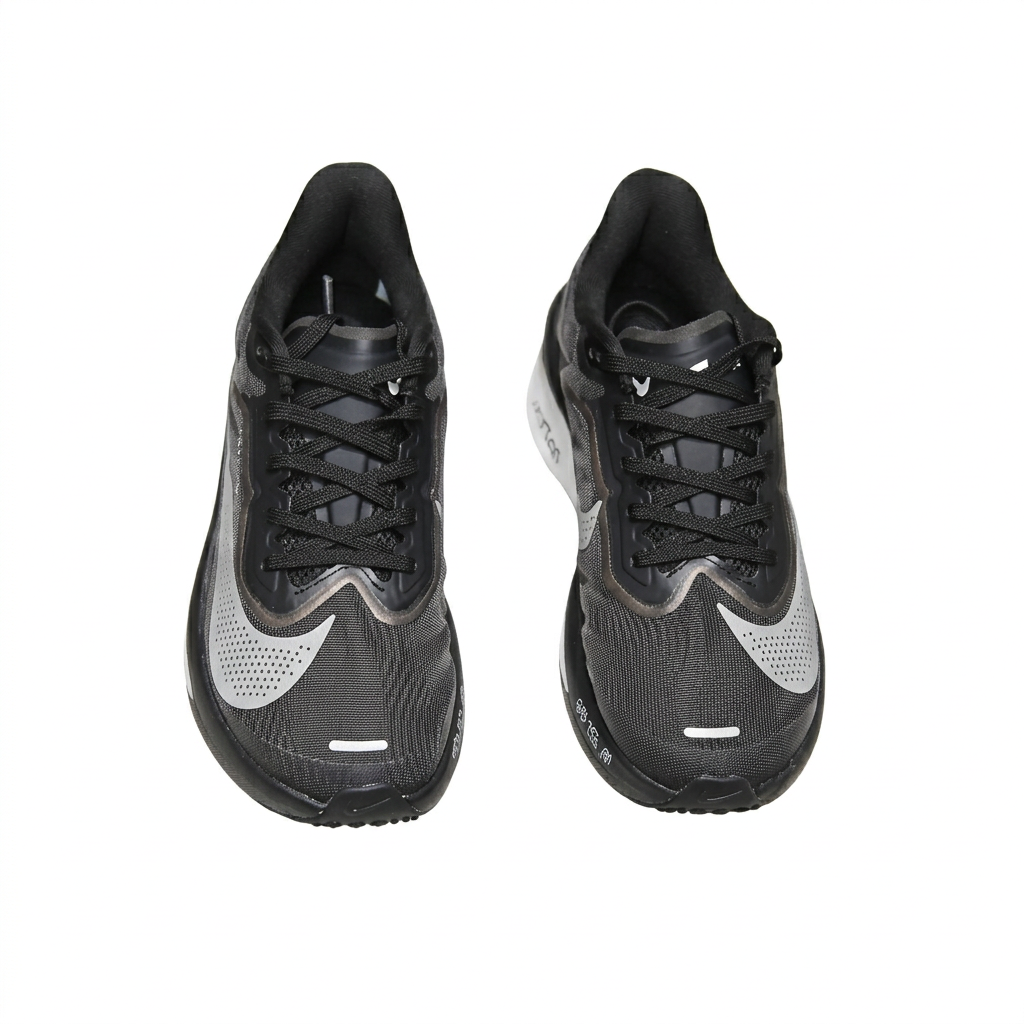 Black Nike sneakers with silver Swooshes, overhead view on white background