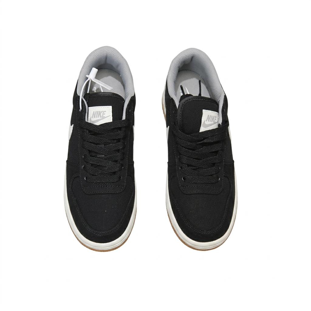 Black Nike sneakers with black laces and grey lining, overhead view on white background