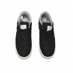 Black Nike sneakers with black laces and grey lining, overhead view on white background