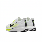 Rear view of white Nike sneakers with black heel strips, neon lime accents and sculpted white soles.
