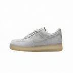 Light grey Nike low-top sneaker with translucent pale yellow sole, side view on white.