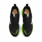 Black Nike sneakers with lime toe accents and black laces, overhead view on white background